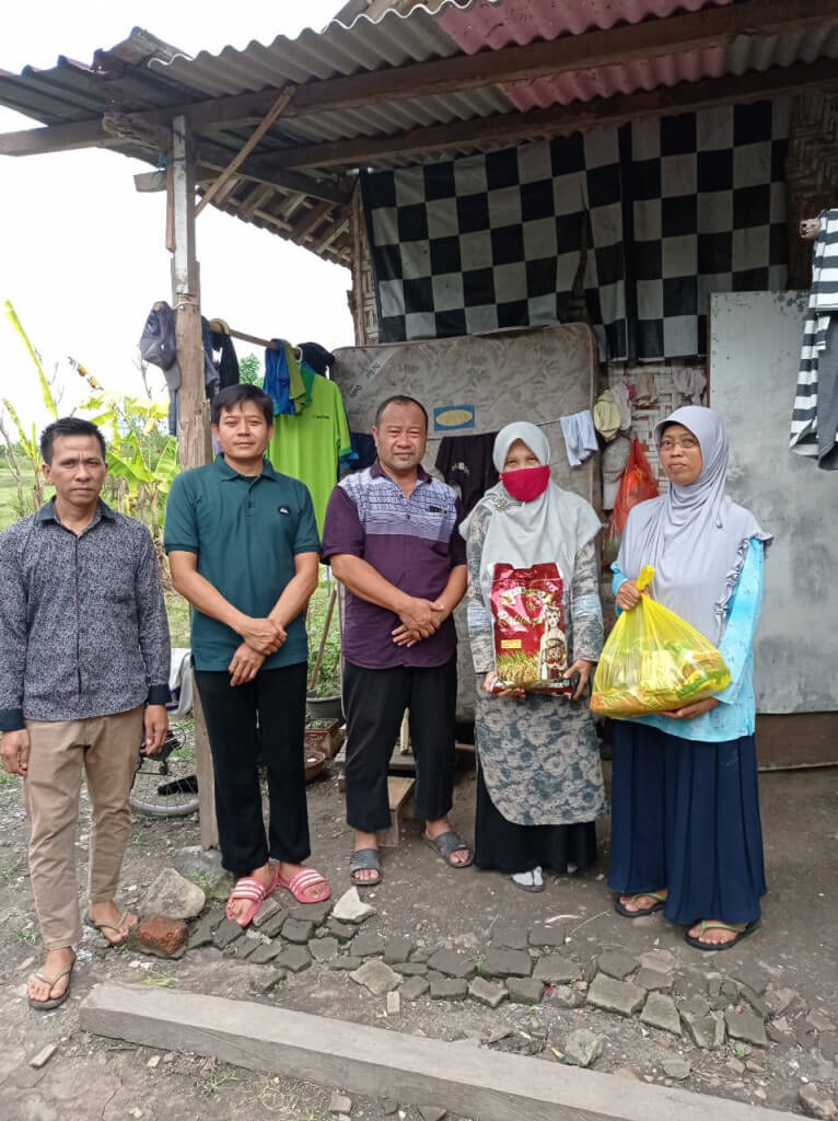 H. Fathol Hadi (tengah) menyerahkan bantuan paket sembako untuk keluarga Ibu Slamet di Tegal Badeng, Jembrana.